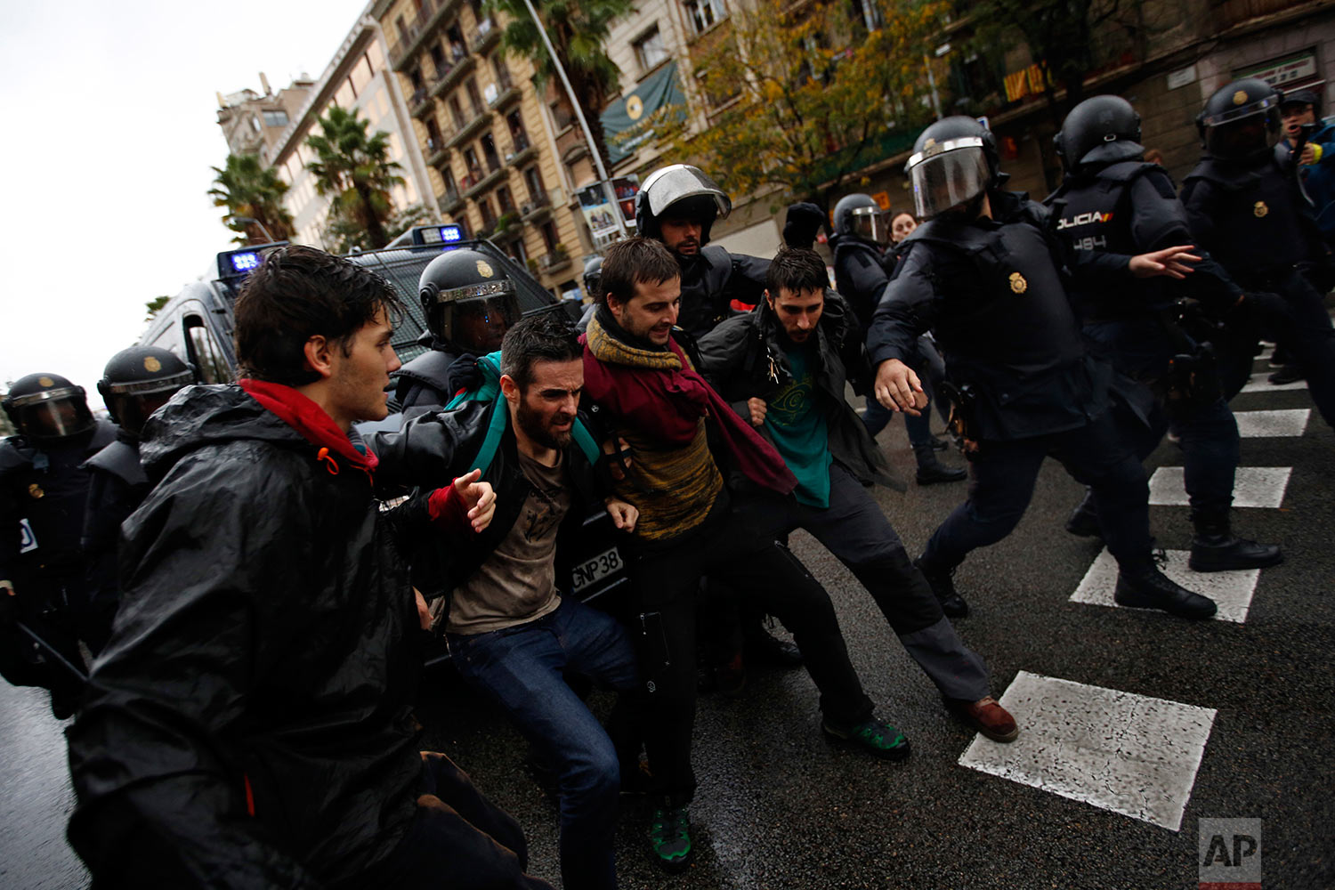 Spanish National Police push away Pro-referendum supporters outside the Ramon Llull school assigned to be a polling station by the Catalan government in Barcelona, Spain, early Sunday, Oct. 1, 2017. Catalan pro-referendum supporters vowed to ignore 