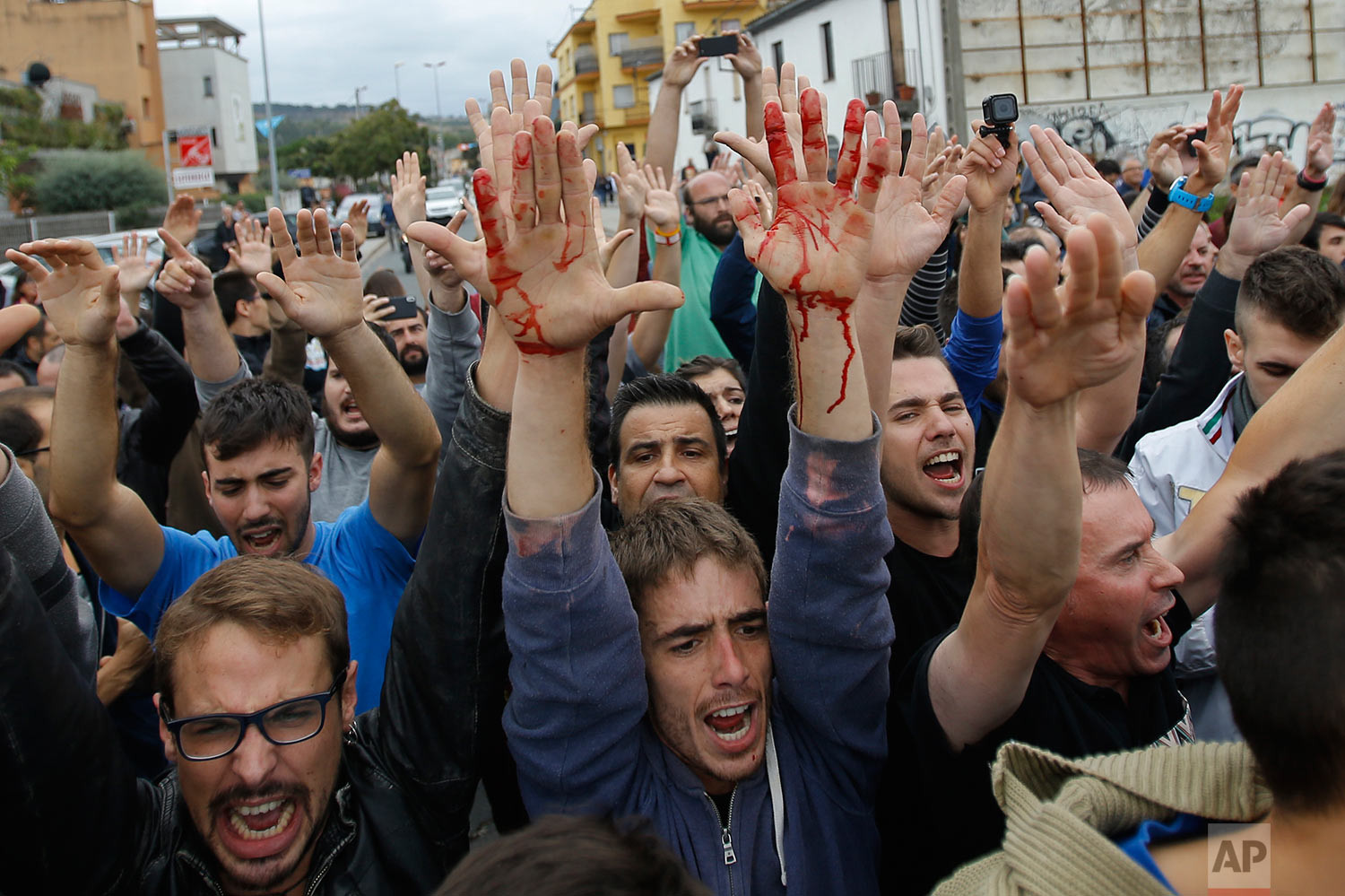  People block the street in a stand off with civil guards in Sant Julia de Ramis, near Girona, Spain, Sunday, Oct. 1, 2017. Scuffles have erupted as voters protested while dozens of anti-rioting police broke into a polling station where the regional 