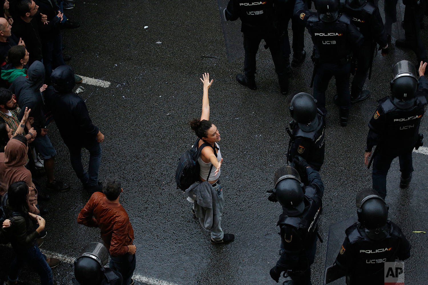  A woman holds her hands up next Spanish National Police as they try to block voters from reaching a voting site at a school assigned to be a polling station by the Catalan government in Barcelona, Spain, Sunday, Oct. 1, 2017. Catalan pro-referendum 