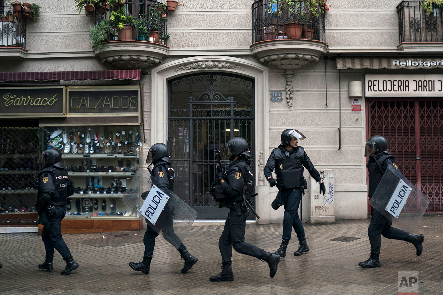  Spanish riot police takes position near a voting site at a school assigned to be a polling station by the Catalan government in Barcelona, Spain, Sunday, Oct. 1, 2017. Spanish riot police have forcefully removed and clashed with would-be voters in s