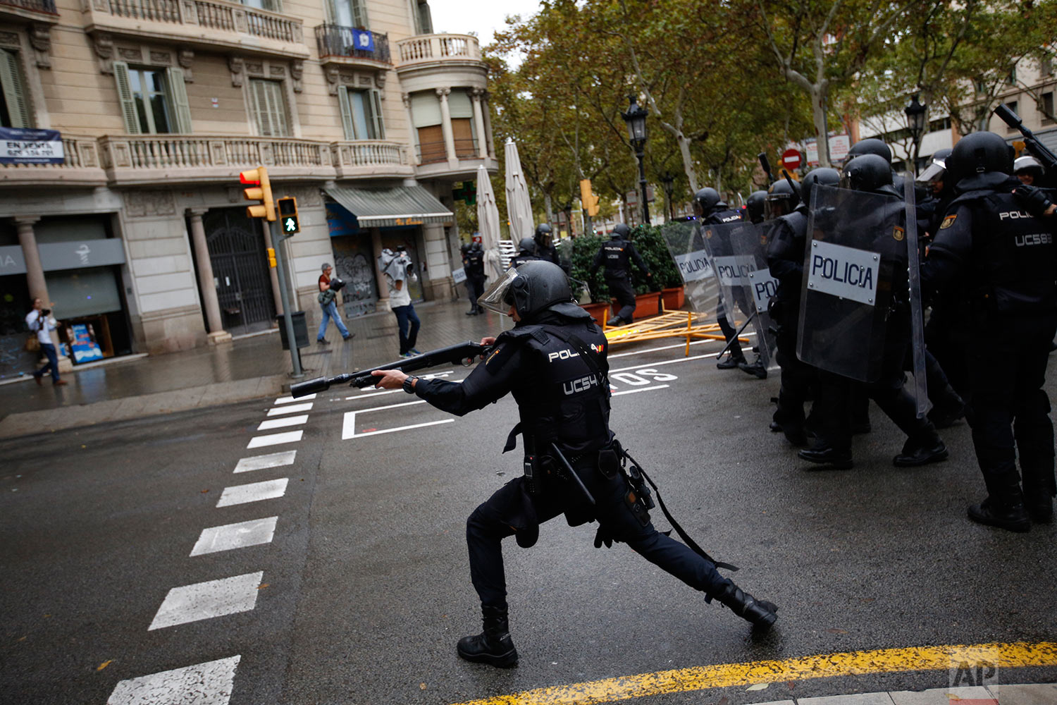  Spanish riot police shoots rubber bullet straight to people trying to reach a voting site at a school assigned to be a polling station by the Catalan government in Barcelona, Spain, Sunday, Oct. 1, 2017. Spanish riot police have forcefully removed a