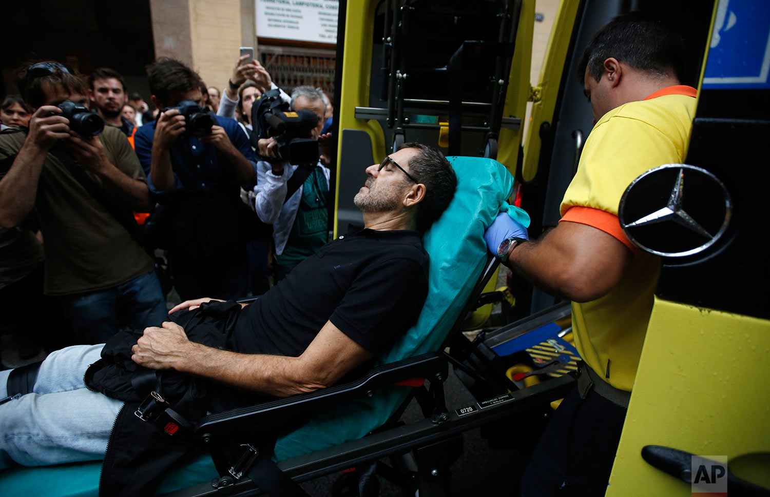  An injured man is taken into an ambulance near a school assigned to be a polling station by the Catalan government in Barcelona, Spain, Sunday, Oct. 1, 2017. Spanish riot police have forcefully removed a few hundred would-be voters from several poll