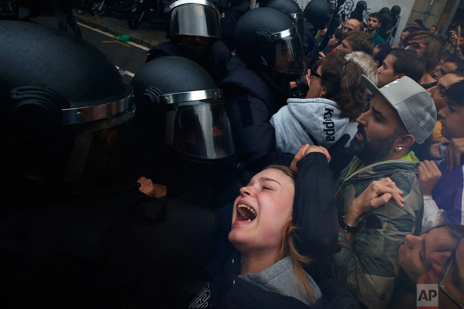 A girl grimaces as Spanish National Police pushes away Pro-referendum supporters outside the Ramon Llull school assigned to be a polling station by the Catalan government in Barcelona, Spain, early Sunday, 1 Oct. 2017. (AP Photo/Emilio Morenatti)