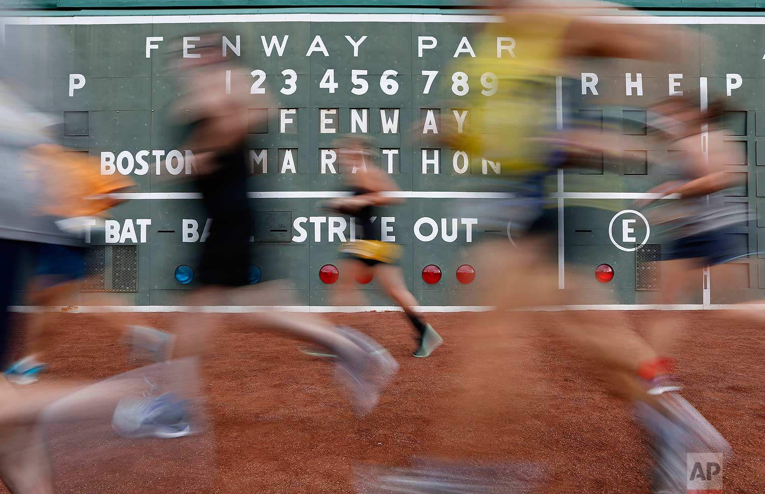  In this image taken with a slow shutter speed, runners compete in the Fenway Marathon at Fenway Park in Boston, Friday, Sept. 15, 2017. The race will take 50 runners around the outfield of Boston's storied baseball stadium 116 times to cover the cla
