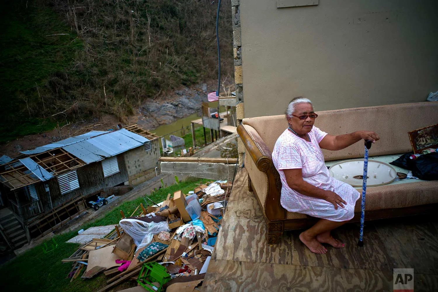 Juana Sortre Vazquez sits on her soaked couch in what remains of her home, destroyed by Hurricane Maria, in the San Lorenza neighborhood of Morovis, Puerto Rico, Saturday, Sept. 30, 2017. (AP Photo/Ramon Espinosa)