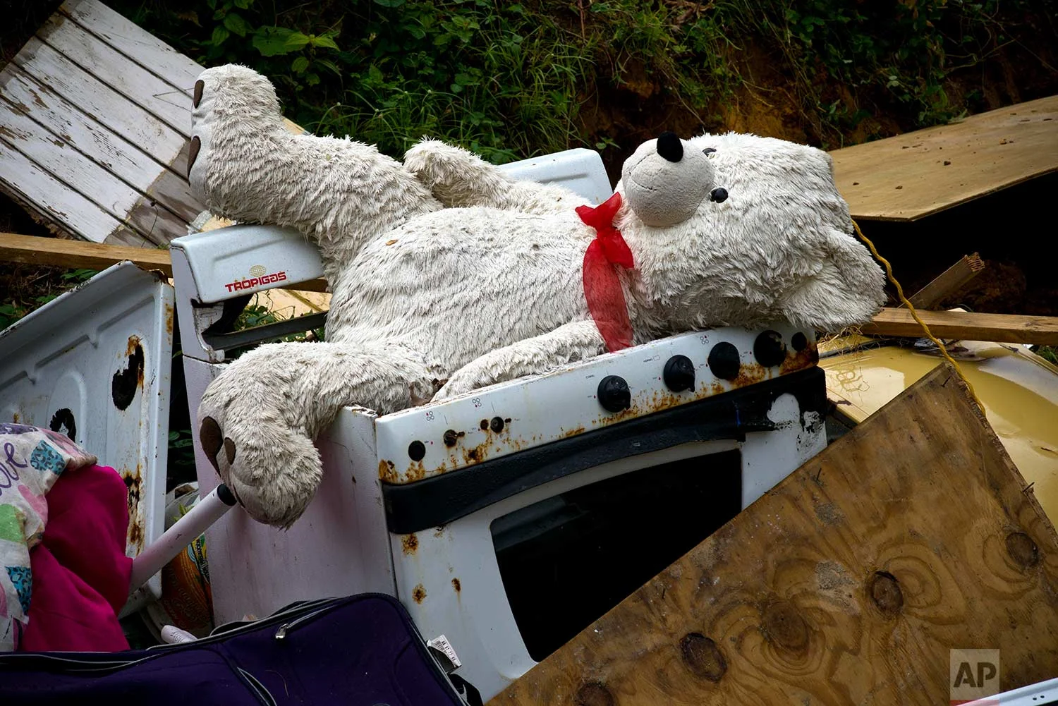 A teddy bear sits on the the belongings of the Sortre family, their home destroyed by Hurricane Maria, in the San Lorenzo neighborhood of Morovis, Puerto Rico, Saturday, Sept. 30, 2017. (AP Photo/Ramon Espinosa)