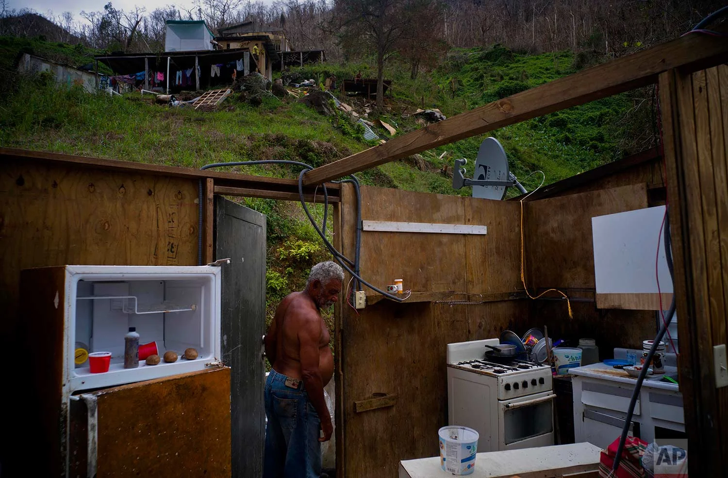 Angel Luis Sortre Vazquez walks into his sister's house destroyed by Hurricane Maria, in the San Lorenzo neighborhood of Morovis, Puerto Rico, Saturday, Sept. 30, 2017. (AP Photo/Ramon Espinosa)