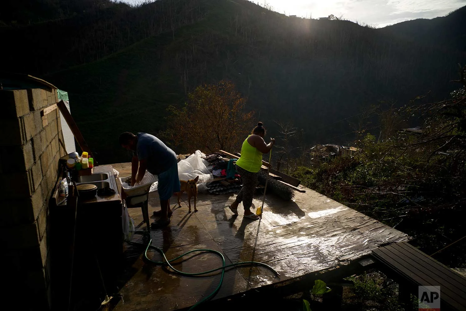 Yadira Sortre and William Fontan Quintero clean what is left of their house, destroyed by Hurricane Maria, in the San Lorenzo neighborhood of Morovis, Puerto Rico, Sunday, Oct. 1, 2017. (AP Photo/Ramon Espinosa)