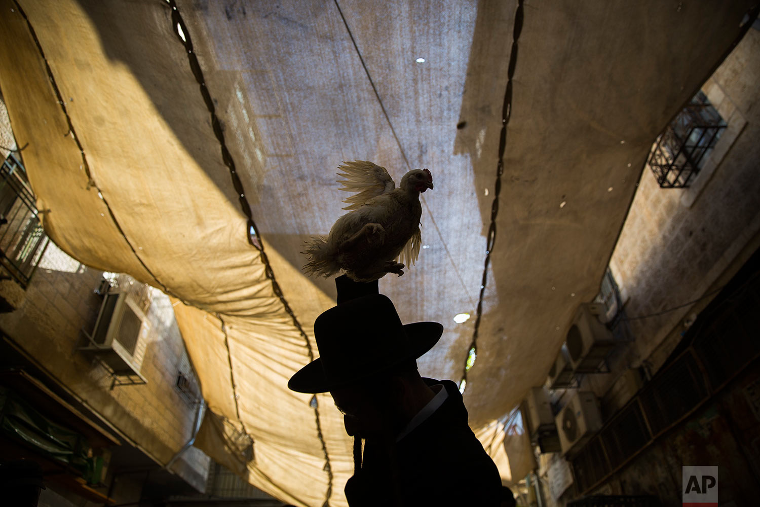 An ultra-Orthodox Jewish man swings a chicken over his head as part of the Kaparot ritual in Jerusalem, Wednesday, Sept. 27, 2017. (AP Photo/Oded Balilty)