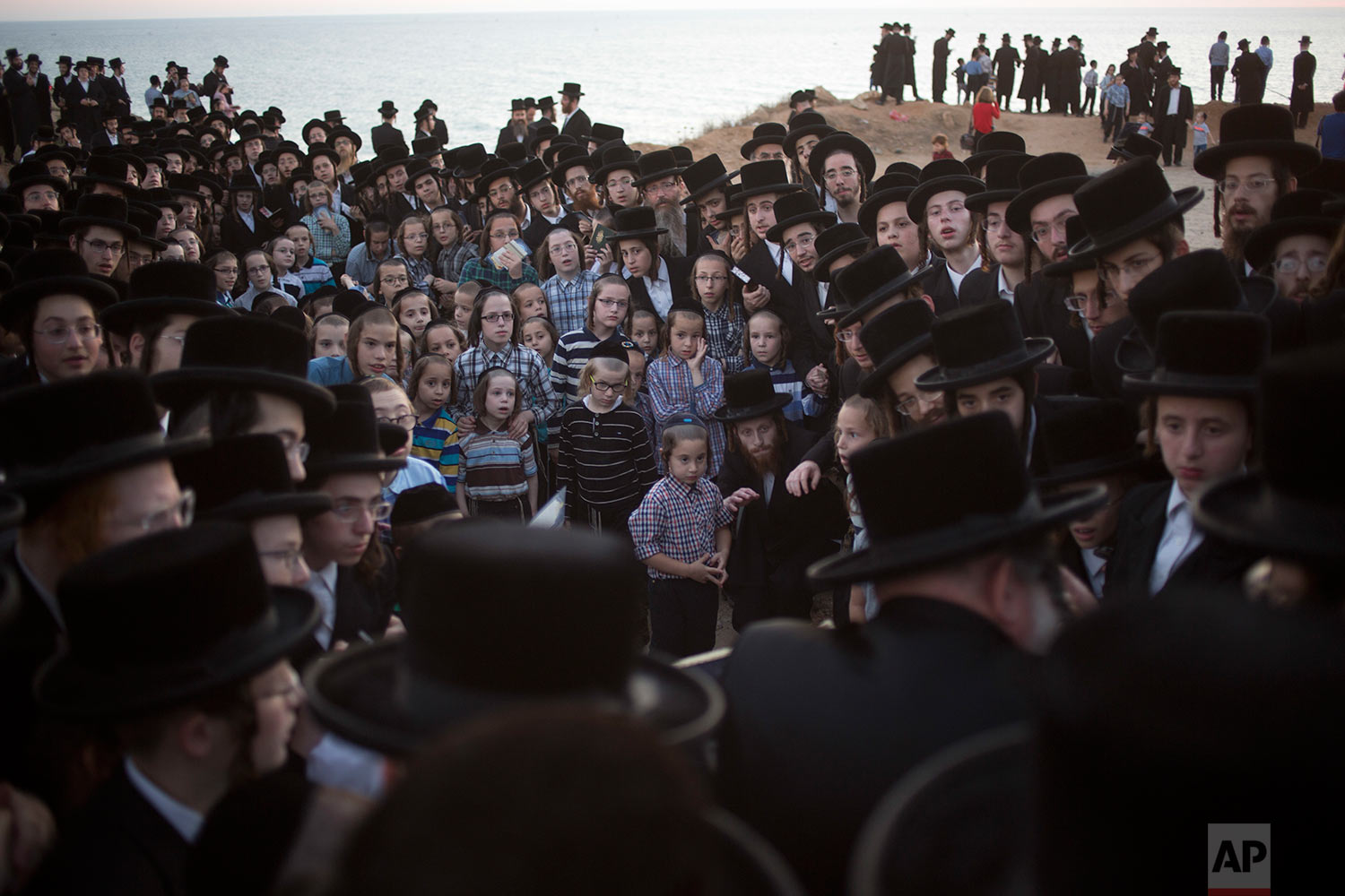  Ultra-Orthodox Jewish men of the Vizhnitz Hassidic sect listen to their rabbi on a hill overlooking the Mediterranean Sea as they participate in a Tashlich ceremony in Herzeliya, Israel, Thursday, Sept. 28, 2017. (AP Photo/Ariel Schalit) 