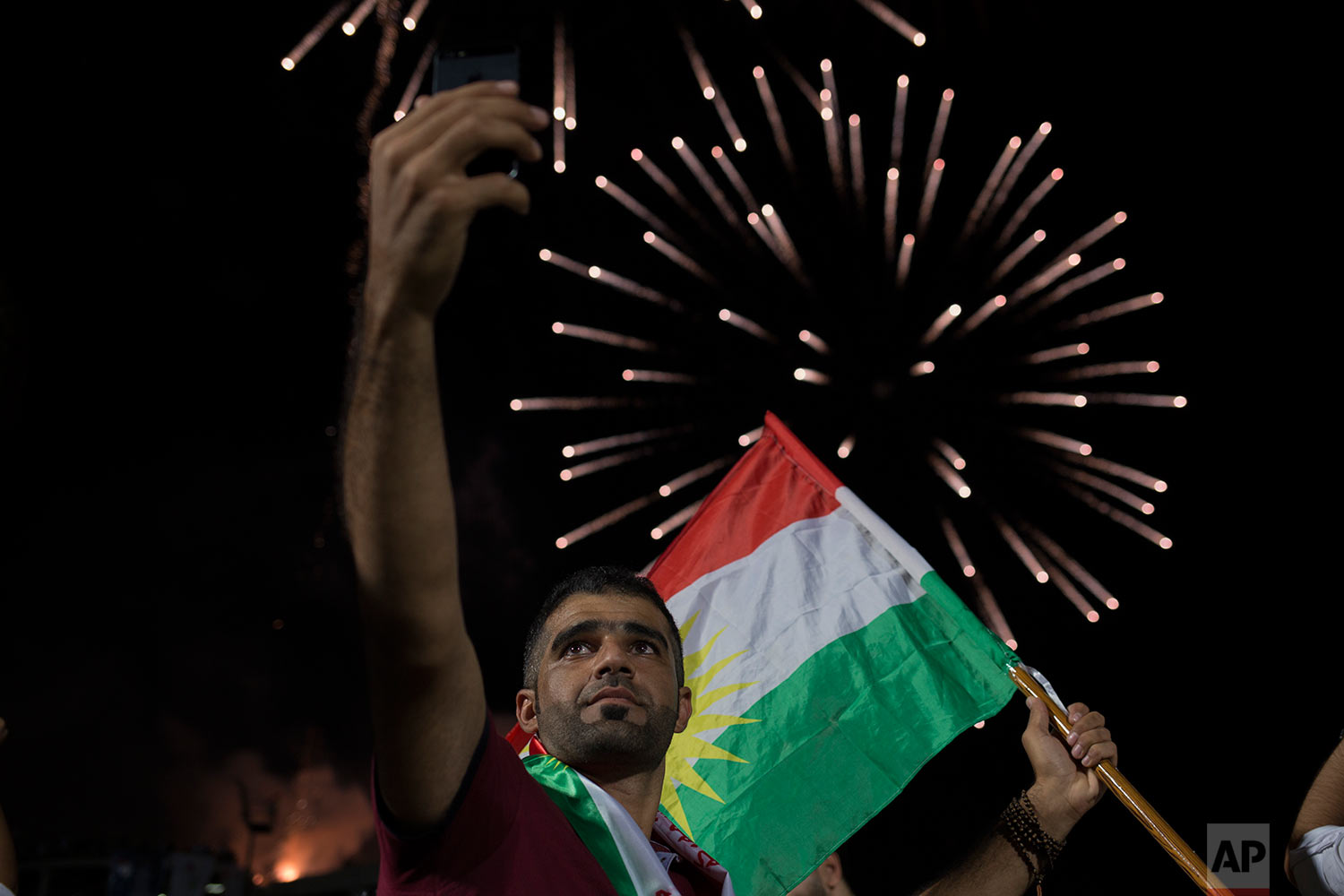  A man takes a selfie in front of a fireworks display at a pro independence rally in Irbil, Friday, Sept. 22, 2017. (AP Photo/Bram Janssen) 