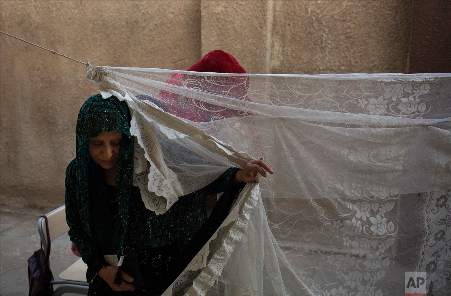 A woman leaves a security checkpoint for women before entering a polling station in the disputed city of Kirkuk, Monday, Sept. 25, 2017. (AP Photo/Bram Janssen)