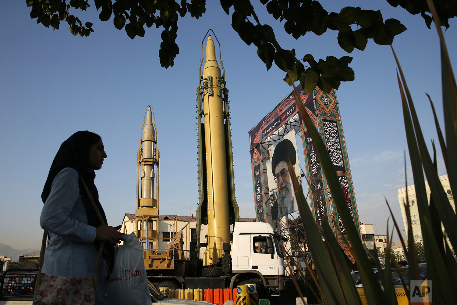 A Ghadr-H missle, center, a solid-fuel surface-to-surface Sejjil missile and a portrait of the Supreme Leader Ayatollah Ali Khamenei are on display for the annual Defense Week, marking the 37th anniversary of the 1980s Iran-Iraq war, at Baharestan Sq. in Tehran, Iran, Sunday, Sept. 24, 2017. (AP Photo/Vahid Salemi)