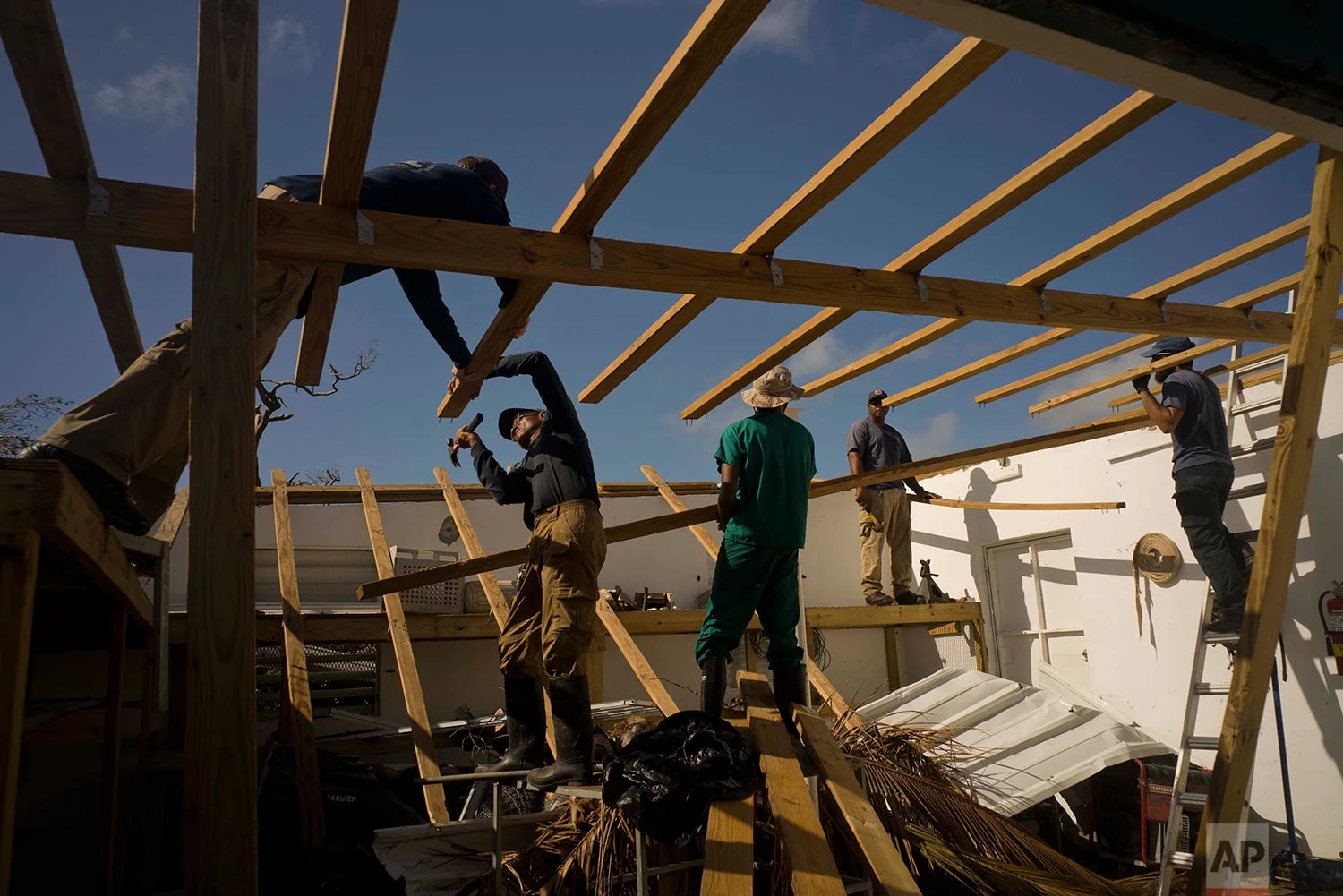 In this Wednesday, Oct. 4, 2017 photo, workers repair research facilities destroyed by Hurricane Maria in Cayo Santiago, known as Monkey Island, in Puerto Rico, one of the world’s most important sites for research into how primates think, socialize and evolve. (AP Photo/Ramon Espinosa)