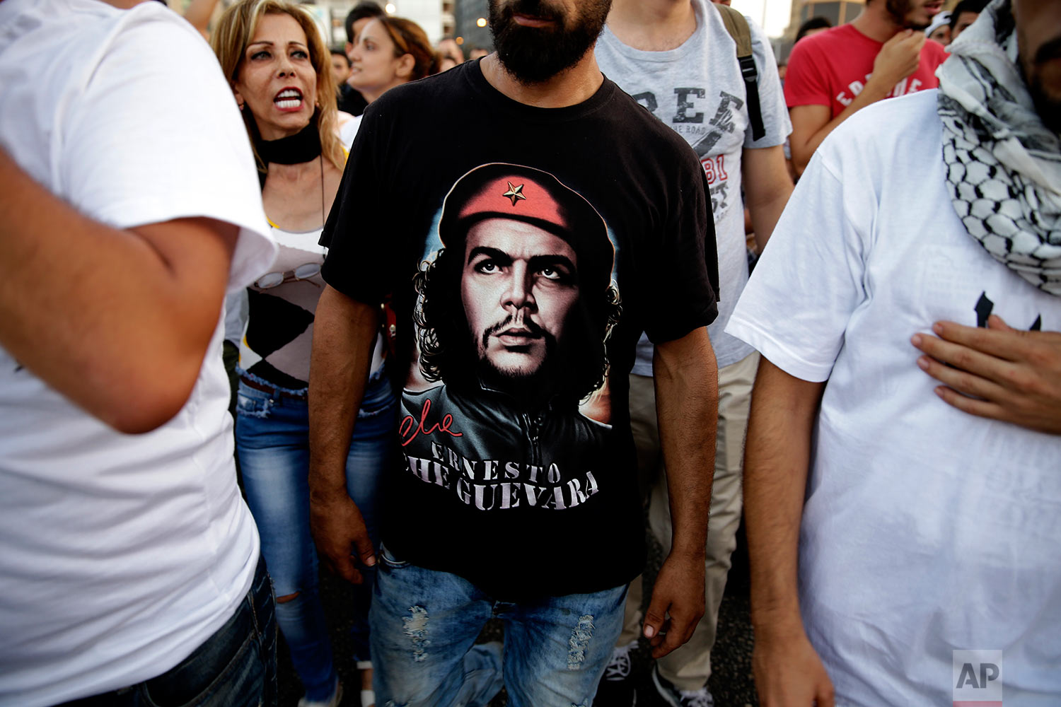  A Lebanese activist wears a portrait of ''Che Guevara'' as others chant slogans during a protest against the trash crisis and government corruption, in downtown Beirut, Lebanon, Wednesday, Aug. 26, 2015. (AP Photo/Hassan Ammar) 