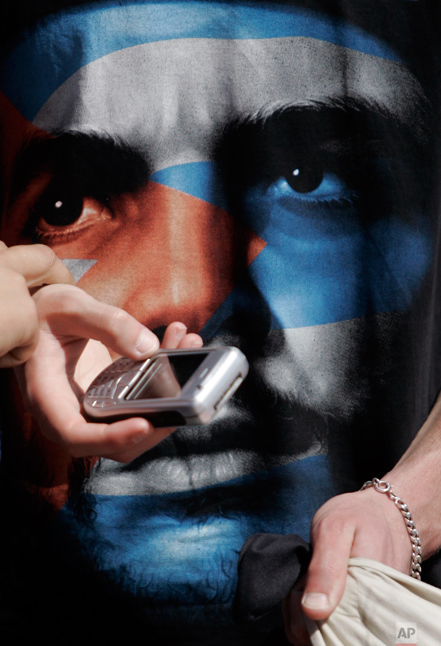 A young man wearing a T-shirt with an image of Cuban revolution leader Ernesto Che Guevara, shows a cellular phone to a friend during a Workers' Day march Thursday, May 1 2008, in Lisbon. (AP Photo/Armando Franca) 
