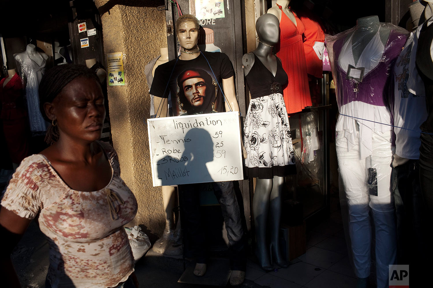  A woman walks past a dummy wearing a t-shirt of Cuban revolutionary Ernesto "Che" Guevara at the Petion Ville neighborhood in Port-au-Prince, Haiti, Thursday, Feb. 3, 2011. (AP Photo/Rodrigo Abd) 