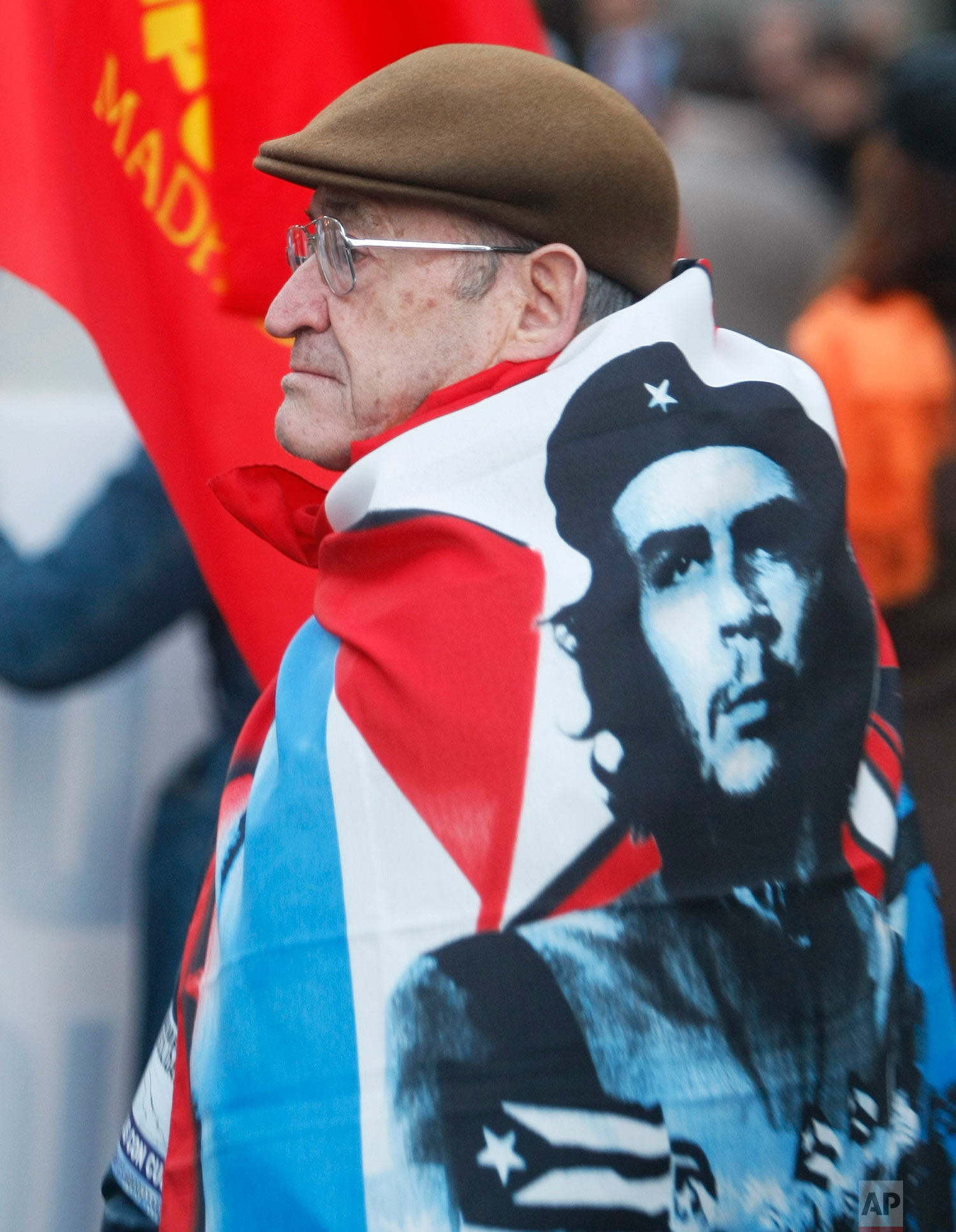  A demonstrator draped with a flag showing the face of Che Guevara, the legendary guerrilla and revolutionary icon, marches in Madrid Saturday Jan. 31, 2009  to mark the the 50th Anniversary of the Cuban Revolution. (AP Photo/Paul White) 