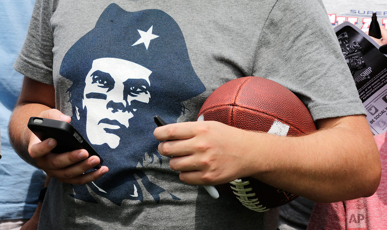  A New England Patriots fan, wearing a Che Guevara-like t-shirt depicting quarterback Tom Brady, waits for a chance to get an autograph during an NFL football training camp in Foxborough, Mass., Thursday, July 30, 2015. (AP Photo/Charles Krupa) 