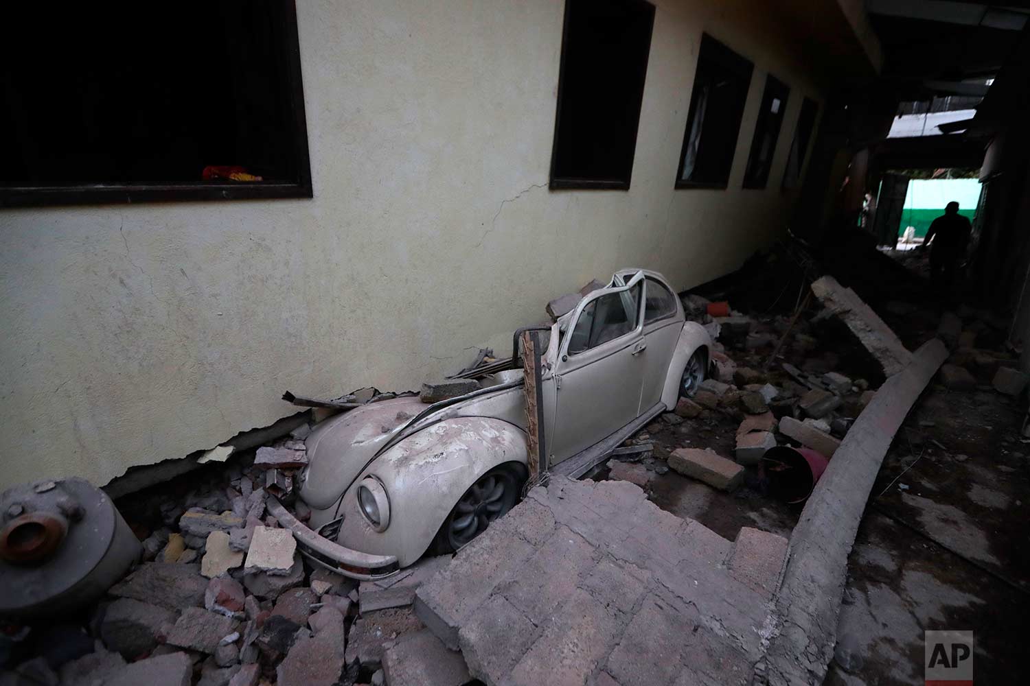 In this Sept. 20, 2017 photo, a car sits crushed from a building felled by a 7.1 earthquake, in Jojutla, Morelos state, Mexico. (AP Photo/Eduardo Verdugo)