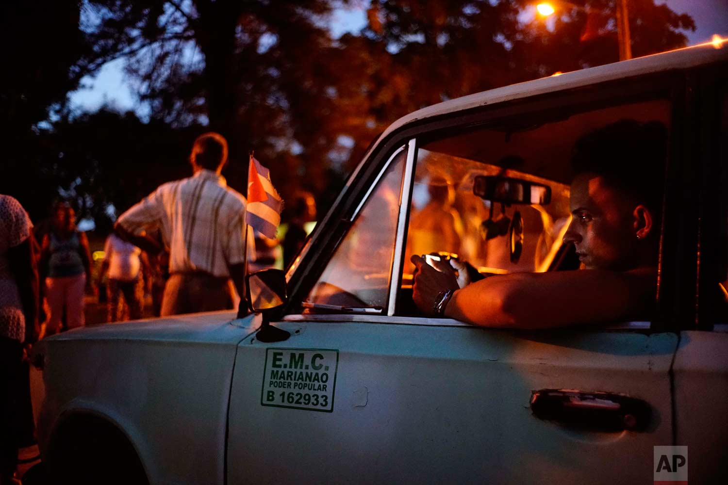 In this Monday, Sept. 4, 2017 photo, a local government employee waits inside an official vehicle used to move the electoral supplies as residents vote to nominate municipal delegate candidates in the district of Marianao in Havana, Cuba. (AP Photo/Ramon Espinosa)