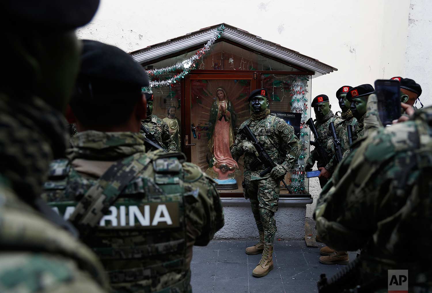A soldiers poses for a photo with a statue of the Virgin of Guadalupe before the start of the annual Independence Day military parade in Mexico City's main square, known as the Zocalo, Saturday, Sept. 16, 2017. (AP Photo/Eduardo Verdugo)