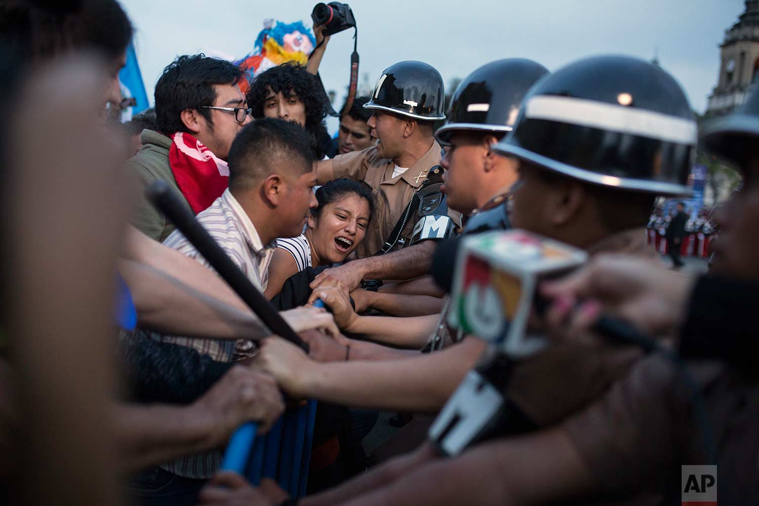 Demonstrators push against a security line of army police as they protest a new penal law approved by Congress, outside the National Palace in Guatemala City, Thursday, Sept. 14, 2017. (AP Photo/Luis Soto)