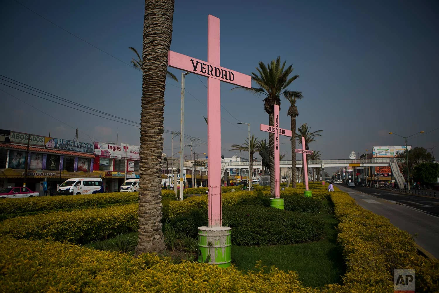 In this Aug. 15, 2007 photo, pink crosses covered with the Spanish words: "Truth," "Justice," and "Restitution" stand in a road median in downtown Nezahualcoyotl, Mexico state. (AP Photo/Rebecca Blackwell)