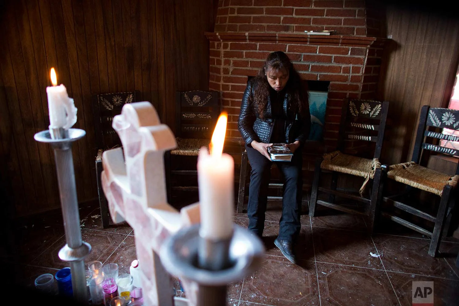 In this Aug. 18, 2017 photo, Juana Pedraza sits beside an altar to her 29-year-old daughter, Jessica, inside the family's home in Villa Cuauhtemoc, Mexico state. (AP Photo/Rebecca Blackwell)