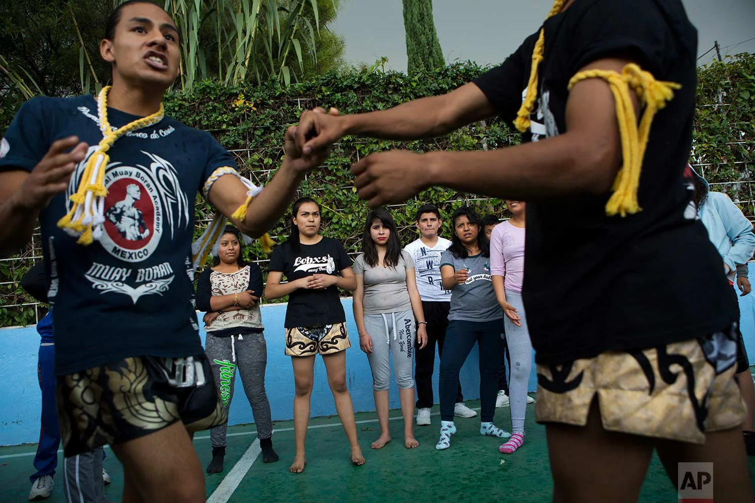 In this Aug. 25, 2017 photo, Muay Thai practitioners demonstrate self-defense moves to mostly female students at a nursing school in Nezahualcoyotl, Mexico state. (AP Photo/Rebecca Blackwell)