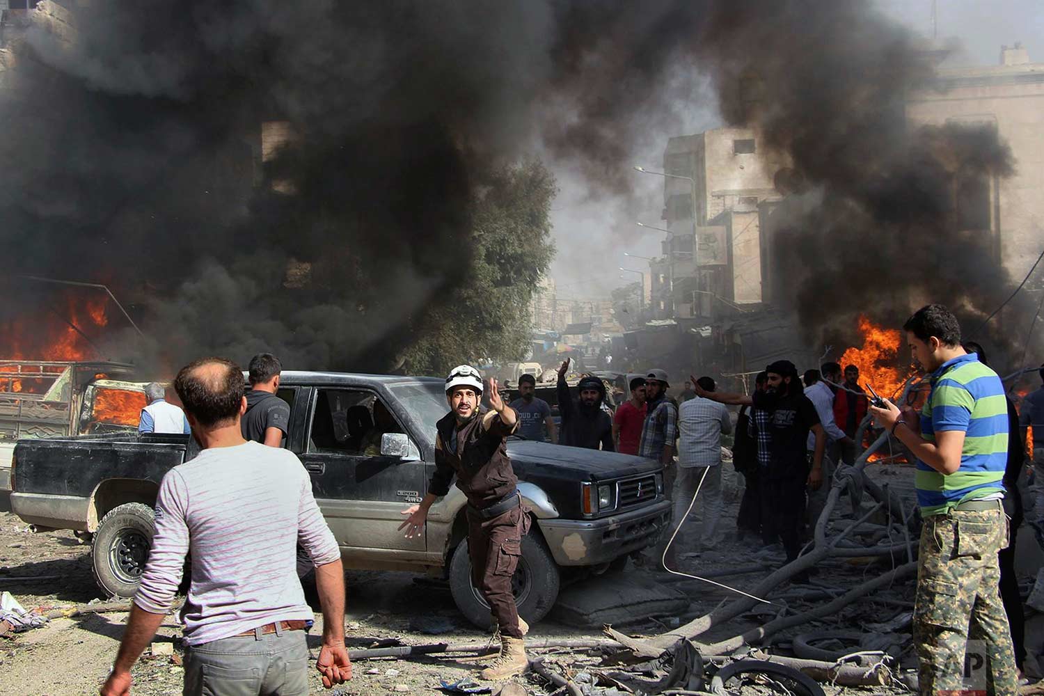  This photo provided by the Syrian Civil Defense White Helmets, which has been authenticated based on its contents and other AP reporting, shows Civil Defense workers and Syrian citizens gathering after an airstrike hit a market in Maaret al-Numan in