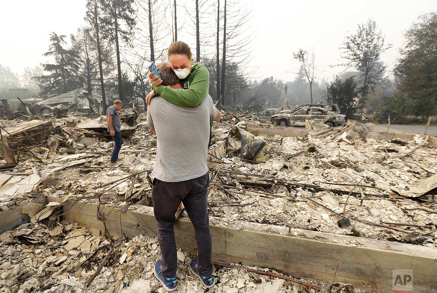  Todd Caughey hugs his daughter, Ella, on Tuesday, Oct. 10, 2017, as they visit the site of their home destroyed by fires in Kenwood, Calif. (AP Photo/Jeff Chiu) 