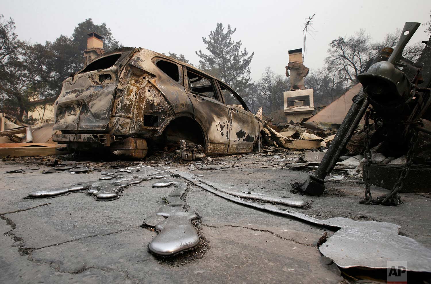  Streams of solidified melted metal reach out from a destroyed vehicle parked at a home Tuesday, Oct. 10, 2017, after a wildfire near Napa, Calif. (AP Photo/Rich Pedroncelli) 