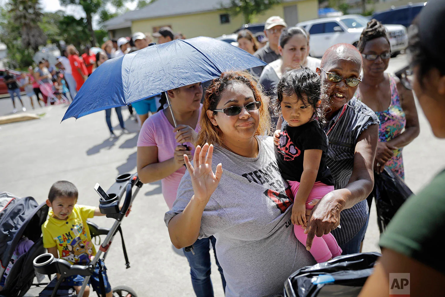People stand in a line for water, food and supplies at a distribution point in Port Arthur, Texas, Monday, Sept. 25, 2017. Jefferson County was drowned by more than 60 inches of rain during Hurricane Harvey, the most rainfall ever recorded in a single storm in the nation's history, according to preliminary data from the National Weather Service. (AP Photo/David Goldman)