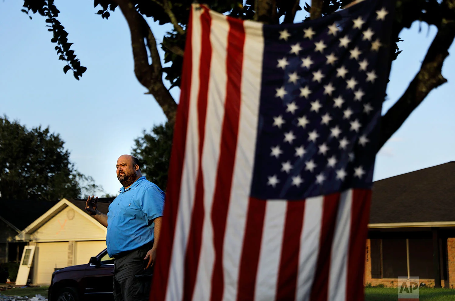 Wilton Johnson stands in Beaumont, Texas, Monday, Sept. 25, 2017, outside the gutted home he shares with his parents that was damaged by Hurricane Harvey. "What good is a great environment if we're poor and living like cavemen? And vice versa, I understand the other side of that: what's great about living in luxury when you can't go outside? I just don't think we should look at two storms and say 'We're ruining the earth! Shut the plants down," said Johnson, who supports Trump's environmental agenda. (AP Photo/David Goldman)
