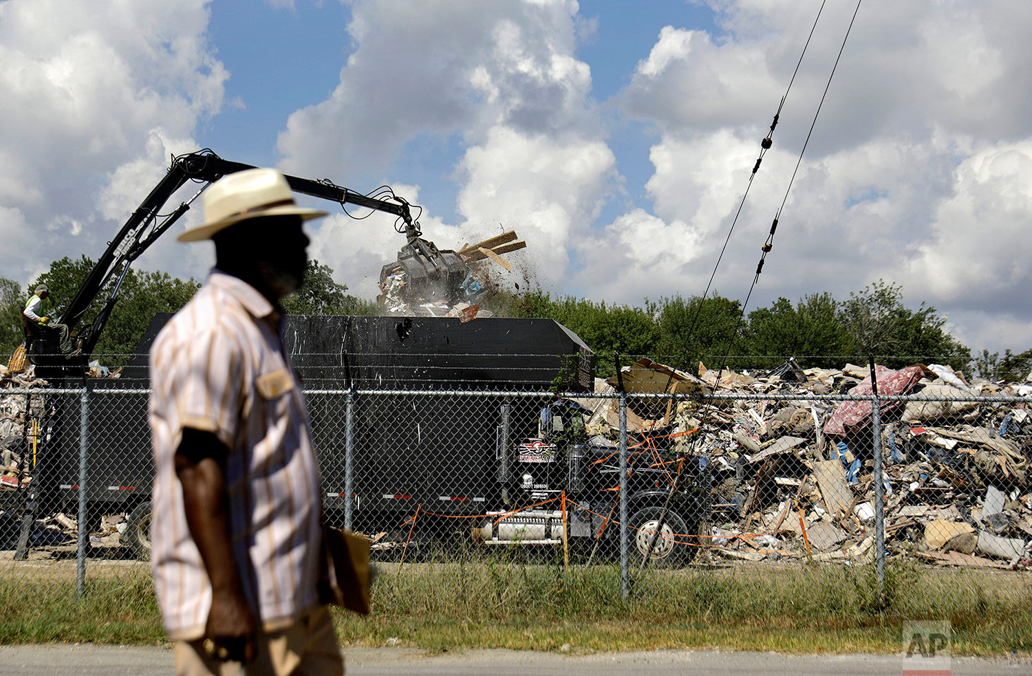  Hilton Kelley walks by as a truck unloads flood damaged debris at a makeshift dump across the street from a residential neighborhood in Port Arthur, Texas, Wednesday, Sept. 27, 2017. Kelley is fighting to get the dump shut down for fear of nearby re