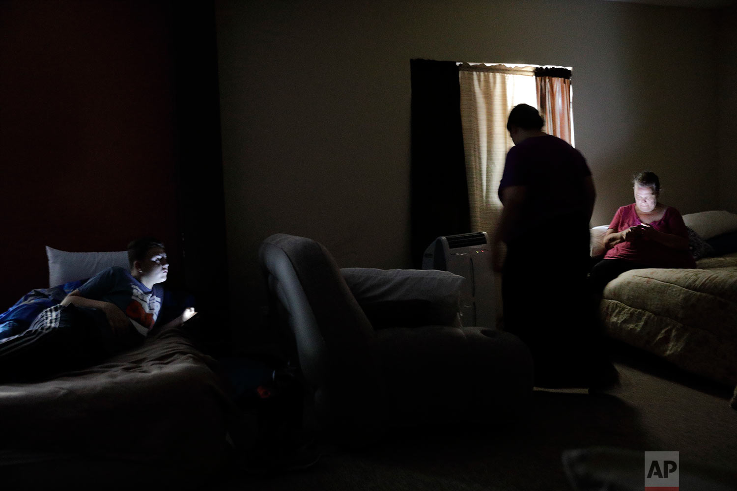  Alice Green, 57, right, sits in the room she shares with her daughter Michelle, 36, center, and grandson Caleb 16, in Port Arthur, Texas, Monday, Sept. 25, 2017. For the past month, they have been living in a church after their home was damaged by H