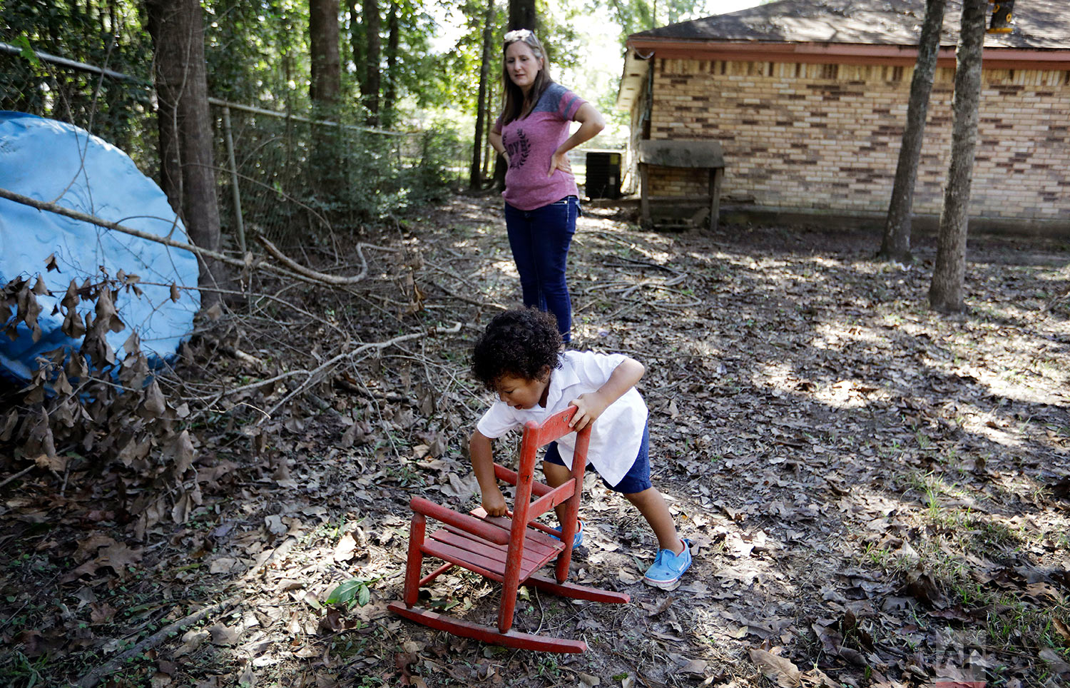  Angela Lopez, watches as her grandson, Carter Gale, 2, cleans dirt off his chair in Beaumont, Texas, Tuesday, Sept. 26, 2017. He found it in the backyard, carried by water from inside their home during Hurricane Harvey flooding. Most of her family, 