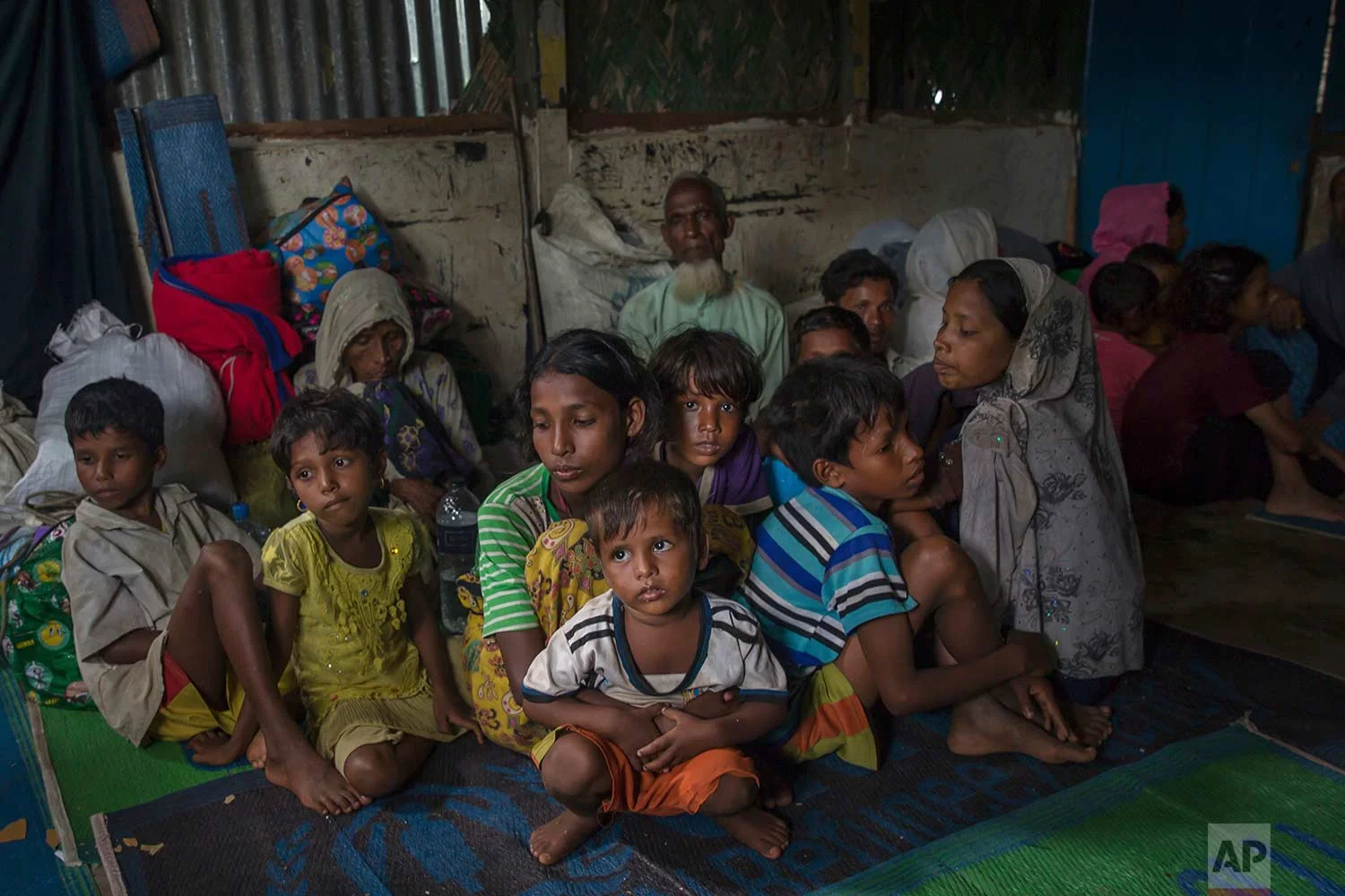 Rohingya Muslims sit inside a classroom waiting to be registered after which they will be allowed to proceed to build a shelter in Kutupalong refugee camp, Bangladesh, Friday, Oct. 20, 2017. (AP Photo/Dar Yasin)