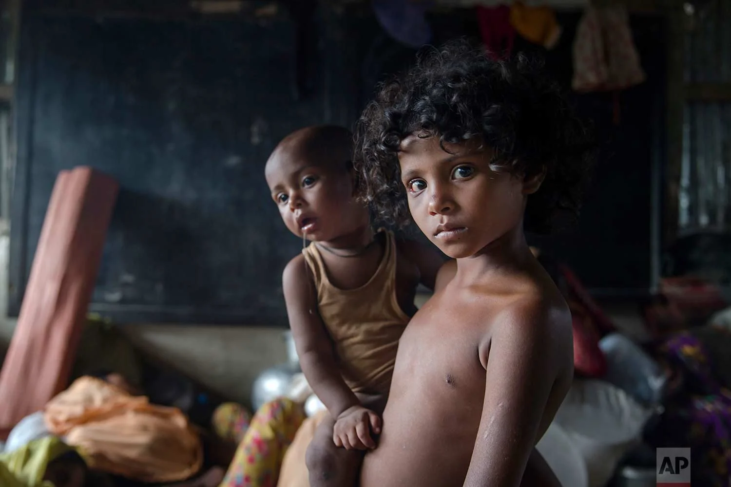A Rohingya Muslim girl Azra, who crossed over from Myanmar into Bangladesh, holds her little brother Luqman and waits for their family to be registered as refugees after which they will be allowed to proceed to build a shelter in Kutupalong refugee camp, Bangladesh, Friday, Oct. 20, 2017.(AP Photo/Dar Yasin)