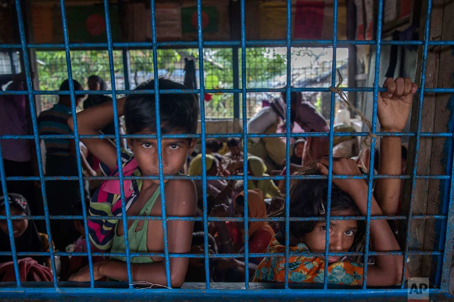 Rohingya Muslim children, who crossed over from Myanmar into Bangladesh, wait inside a classroom for their families to be registered as refugees after which they will be allowed to proceed to build a shelter in Kutupalong refugee camp, Bangladesh, Friday, Oct. 20, 2017. (AP Photo/Dar Yasin)