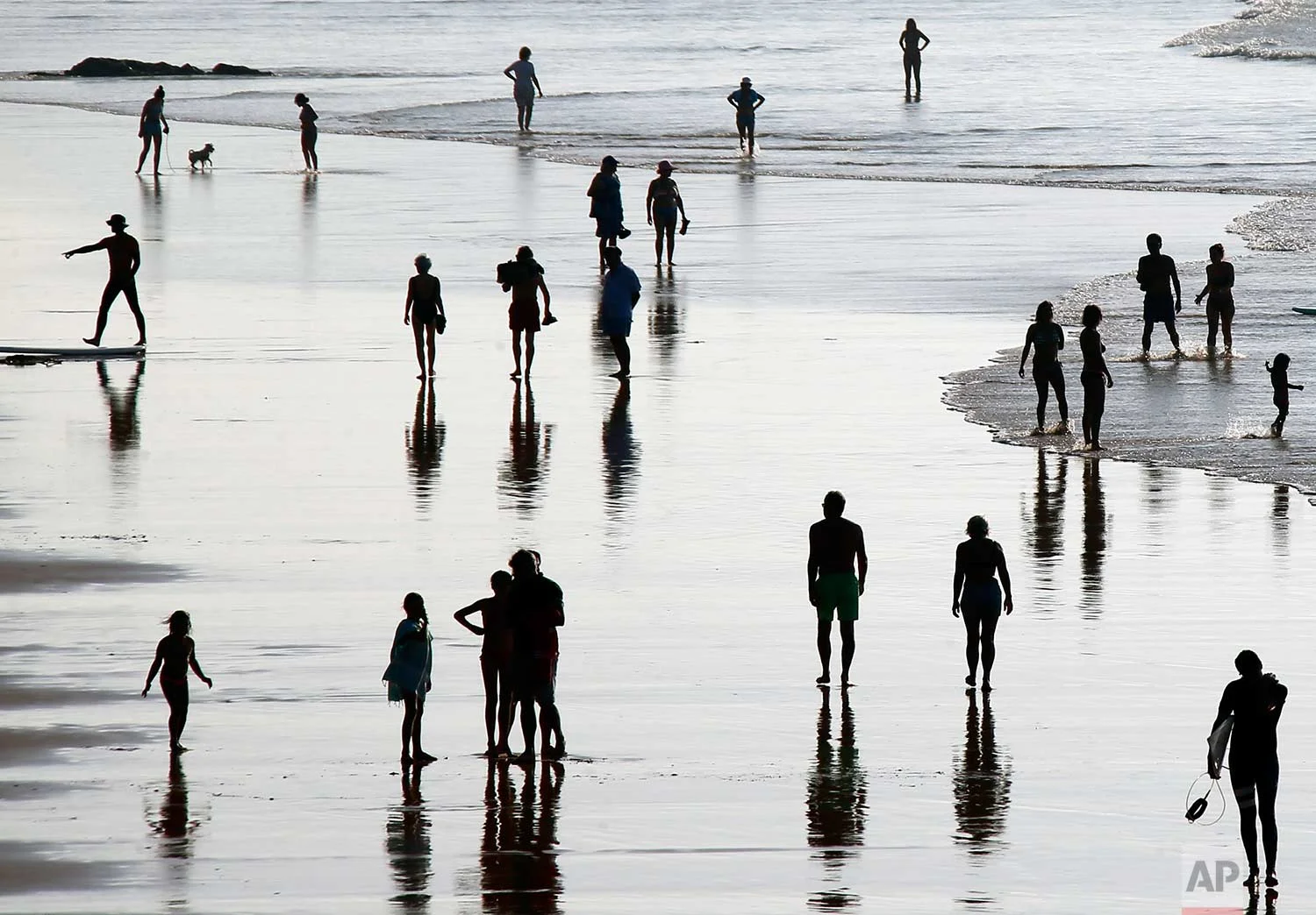 People walk on the beach in Biarritz, southwestern France, Saturday, Oct. 14, 2017. (AP Photo/Bob Edme)