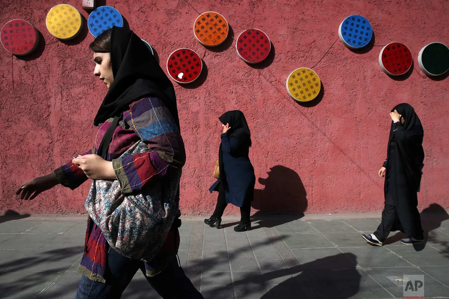 Pedestrians walk down a sidewalk in downtown Tehran, Iran, Saturday, Oct. 14, 2017. (AP Photo/Vahid Salemi)