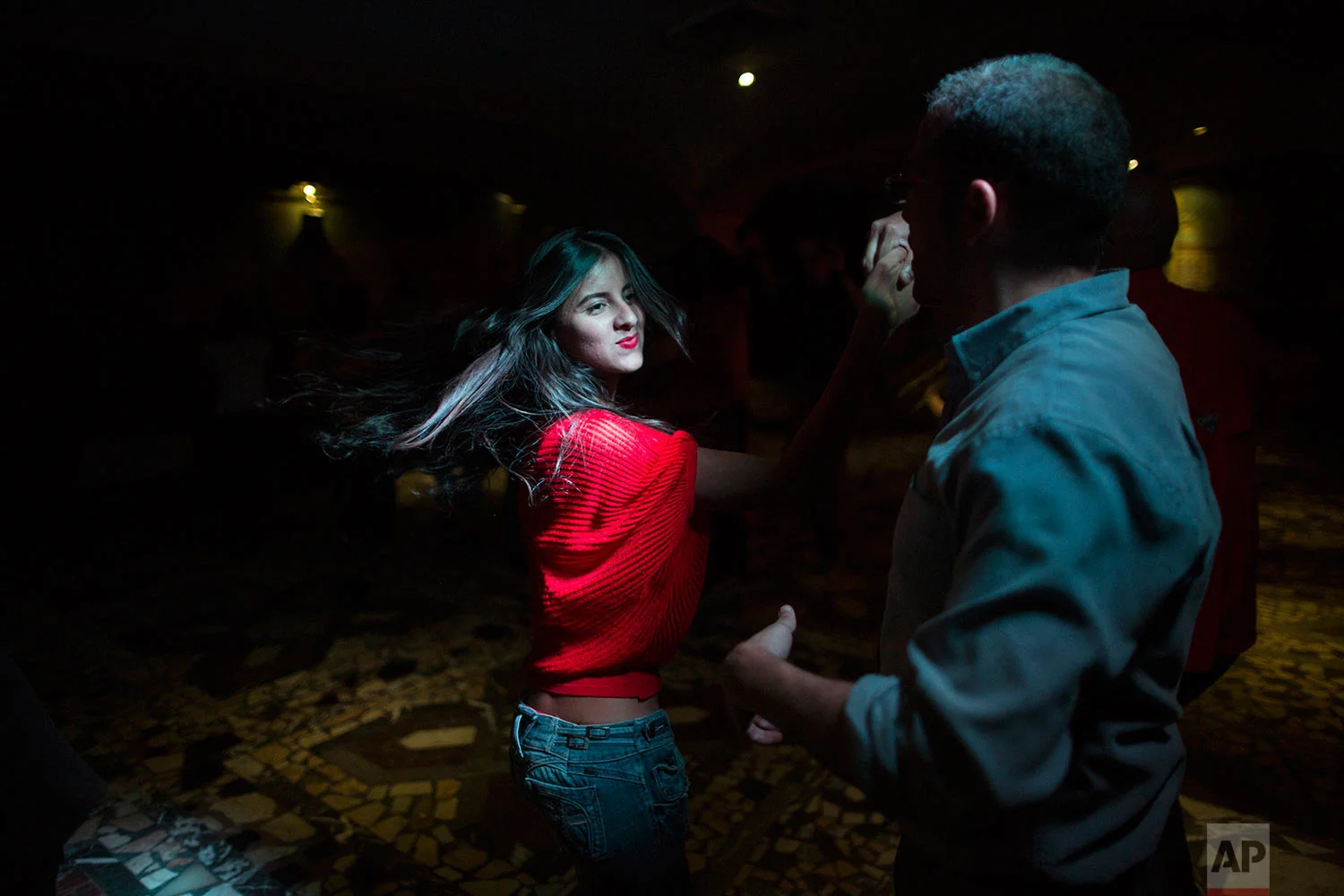 People salsa dance at a club in the financial district of Caracas, Venezuela, Thursday, Oct. 26, 2017. (AP Photo/Rodrigo Abd)