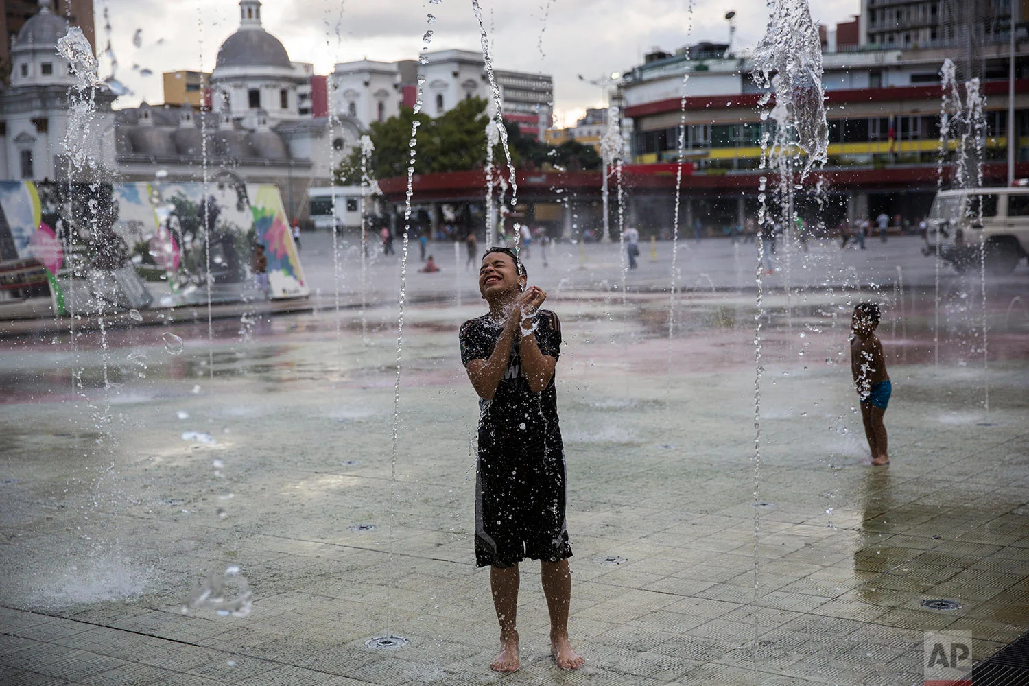 A boy plays in the water at Diego Ibarra Park in downtown Caracas, Venezuela, Monday, Oct. 23, 2017. (AP Photo/Rodrigo Abd)