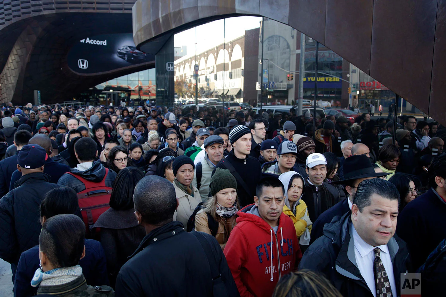 Commuters wait in a line to board buses into Manhattan in front of the Barclays Center in Brooklyn, New York, Thursday, Nov. 1, 2012. The line stretched twice around the arena and commuters reported wait times of one to three hours to get on a bus. (AP Photo/Seth Wenig)
