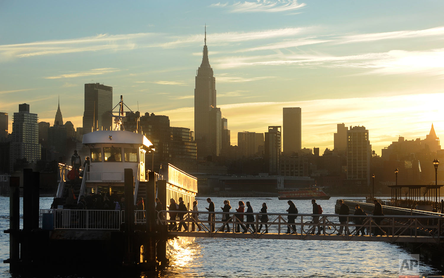 Commuters board a New York Waterway ferry bound for Midtown Manhattan at the 14th Street pier Thursday Nov. 1, 2012 in Hoboken, N.J. New York City moved closer to resuming its frenetic pace by getting back its vital subways Thursday, three days after a superstorm, but neighboring New Jersey was stunned by coastal devastation and the news of thousands of people in one city still stranded by increasingly fetid floodwaters. (AP Photo/Joe Epstein)