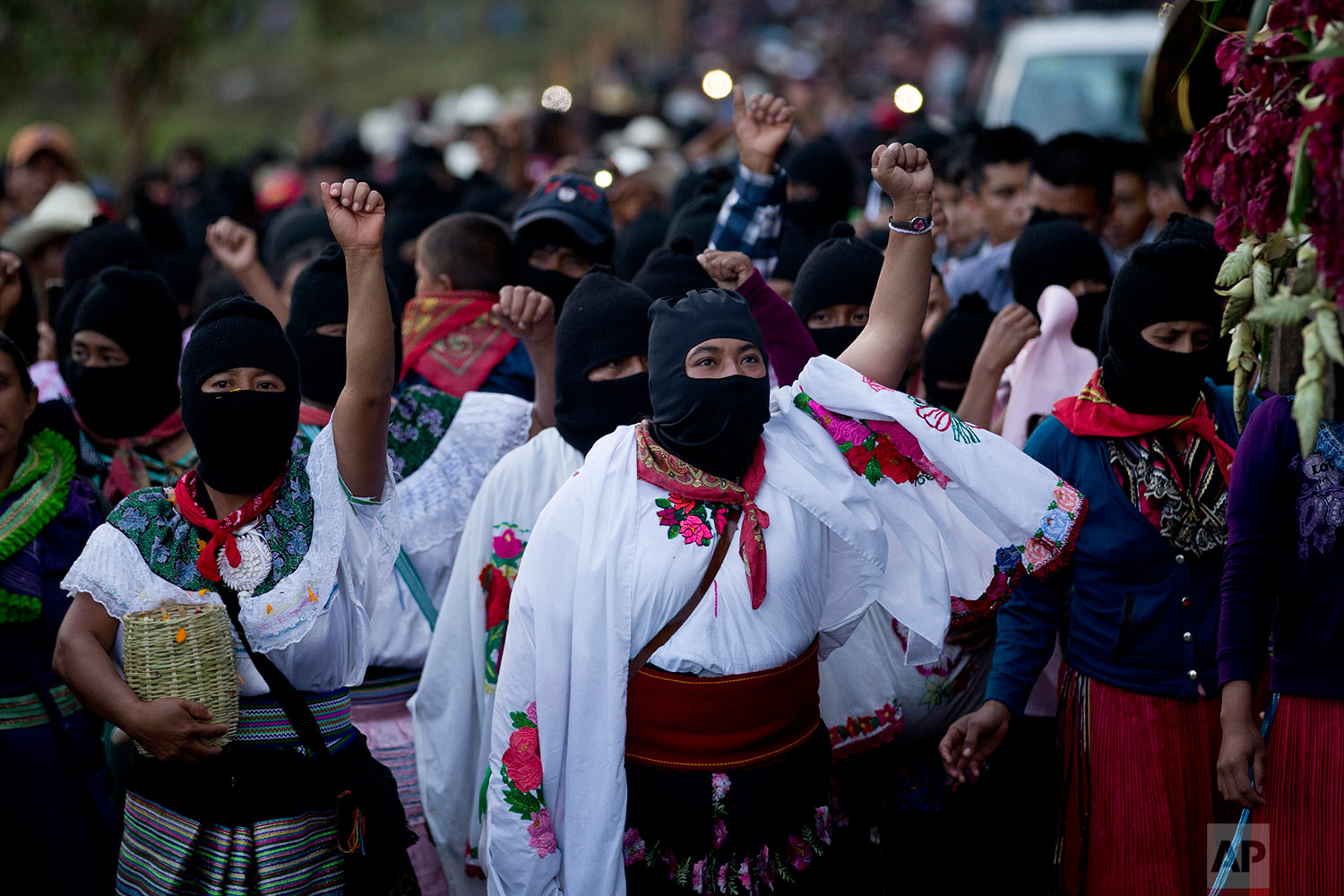  In this Sunday, Oct. 15, 2017 photo, masked indigenous women raise their fists to show support for Maria de Jesus Patricio, presidential candidate for the National Indigenous Congress, during a rally in the Zapatista stronghold of Morelia, in the so