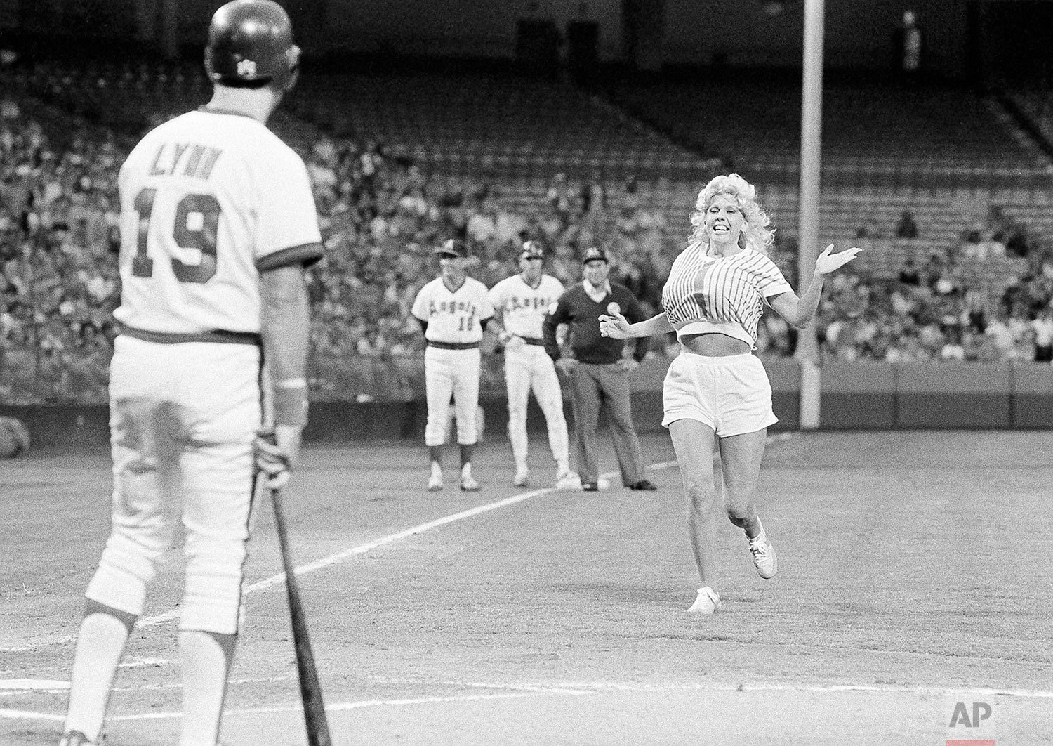  A California Angels fan known as Morganna, runs across the field toward Angels' Fred Lynn to give him a kiss during the first inning in the game with the Chicago White Sox at Anaheim, June 9, 1983. Morganna, on a number of occasions, has run onto th