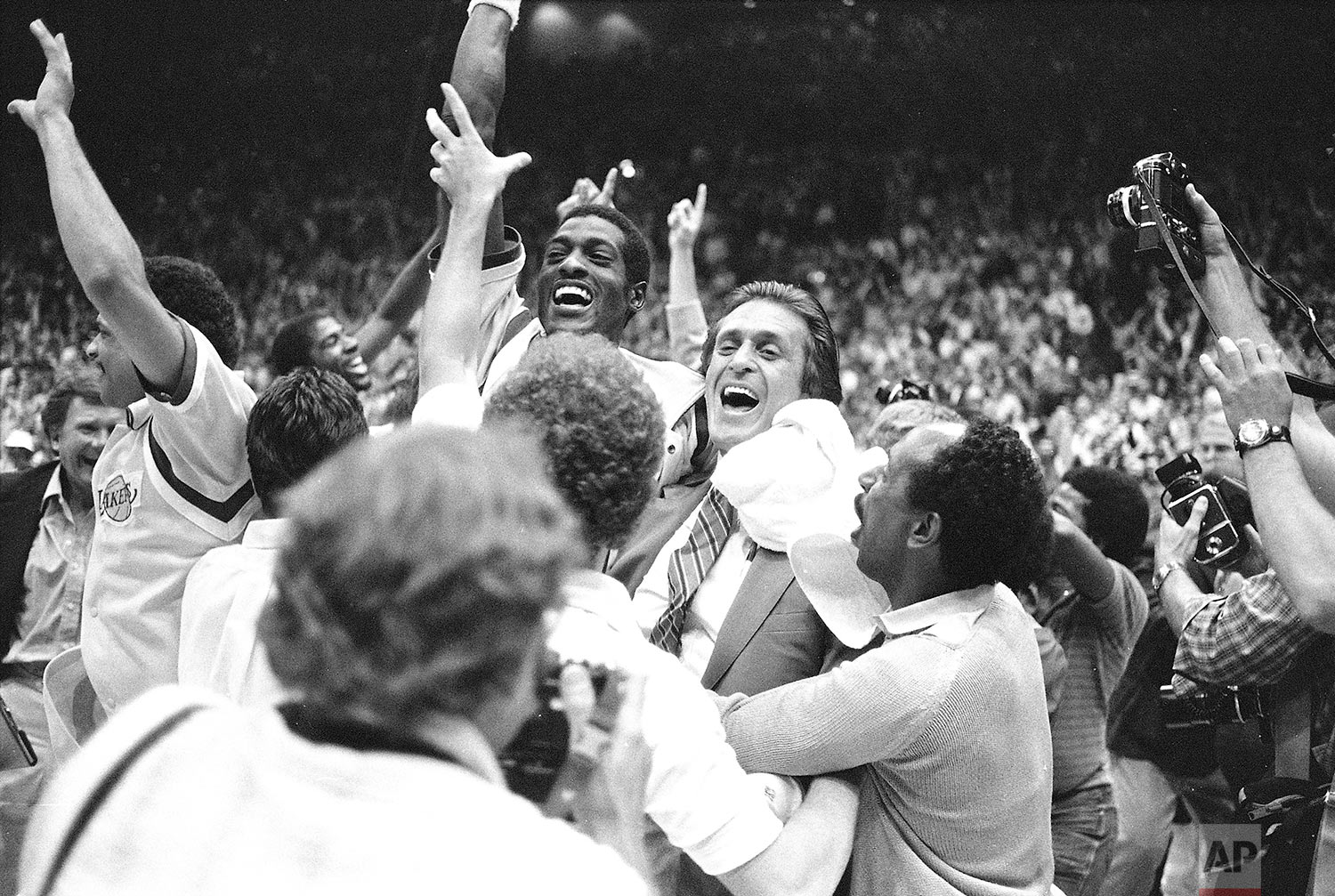  In this June 9, 1982, photo, Los Angeles Lakers head coach Pat Riley, center right, is swamped by fans and players as he and Lakers Mike Cooper leave the court after defeating Philadelphia 76ers 114-104 to win the NBA championship. (AP Photo/Lennox 
